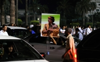 A man holds up a poster of Gaddafi