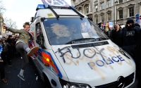 A demonstrator kicks a police van