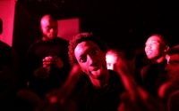 A clubber gestures to the camera at a grime night