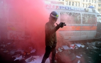 A demonstrator wears a police officer's helmet