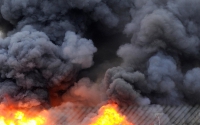 Inmates carry their possessions and walk from burning buildings